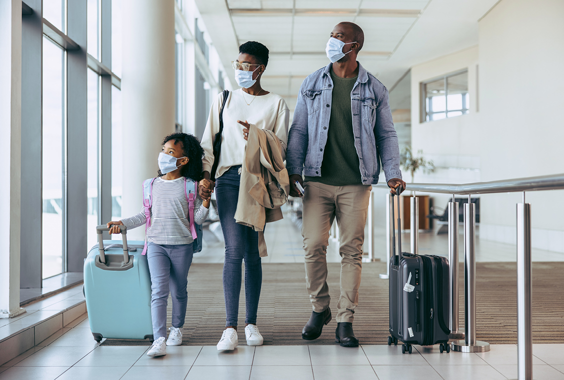 Family in airport with luggage ready to travel